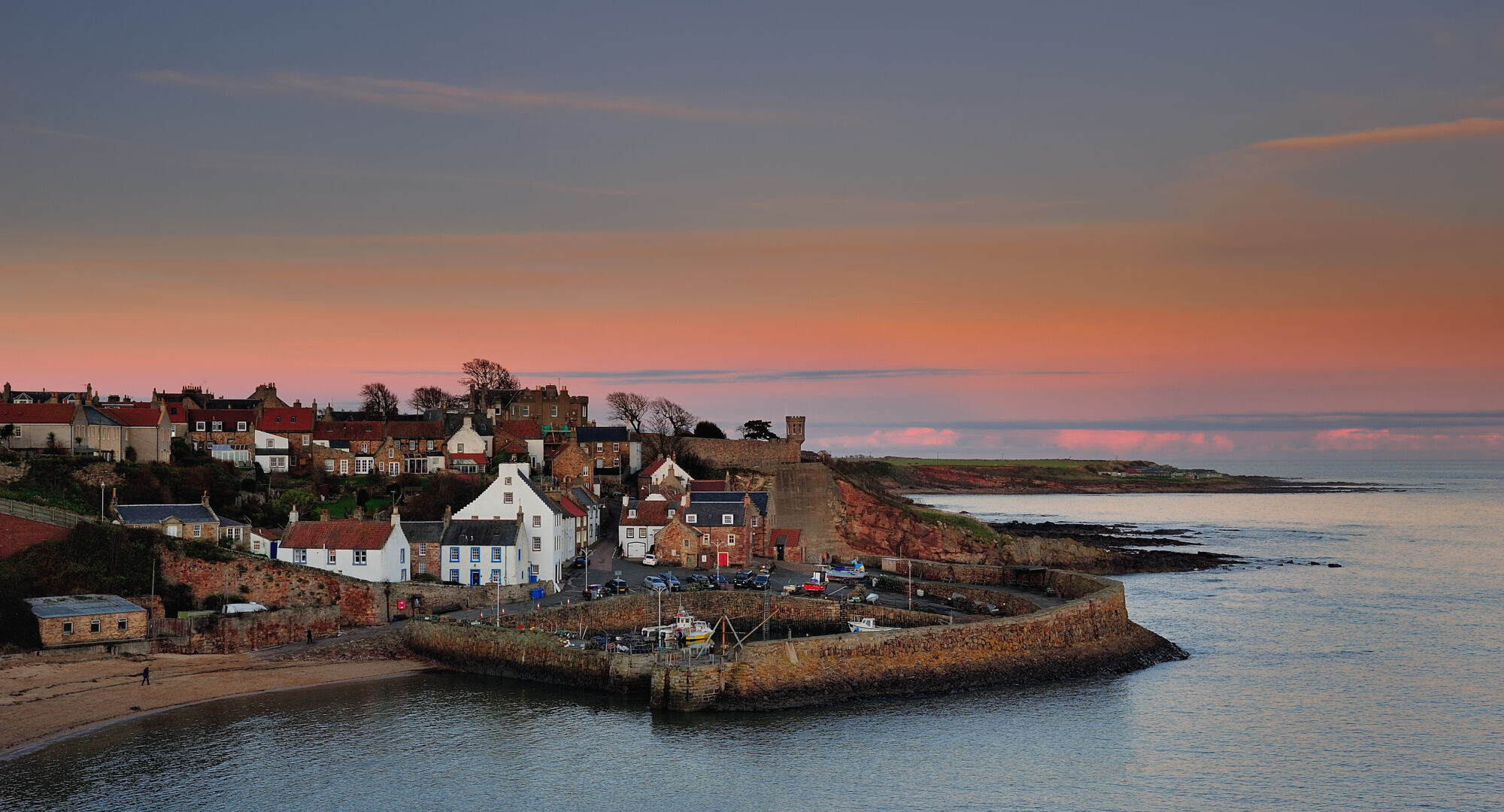 The quaint and picturesque fishing village and harbour of Crail in the East Neuk of Fife, as the last light of day fades across the Firth of Forth.