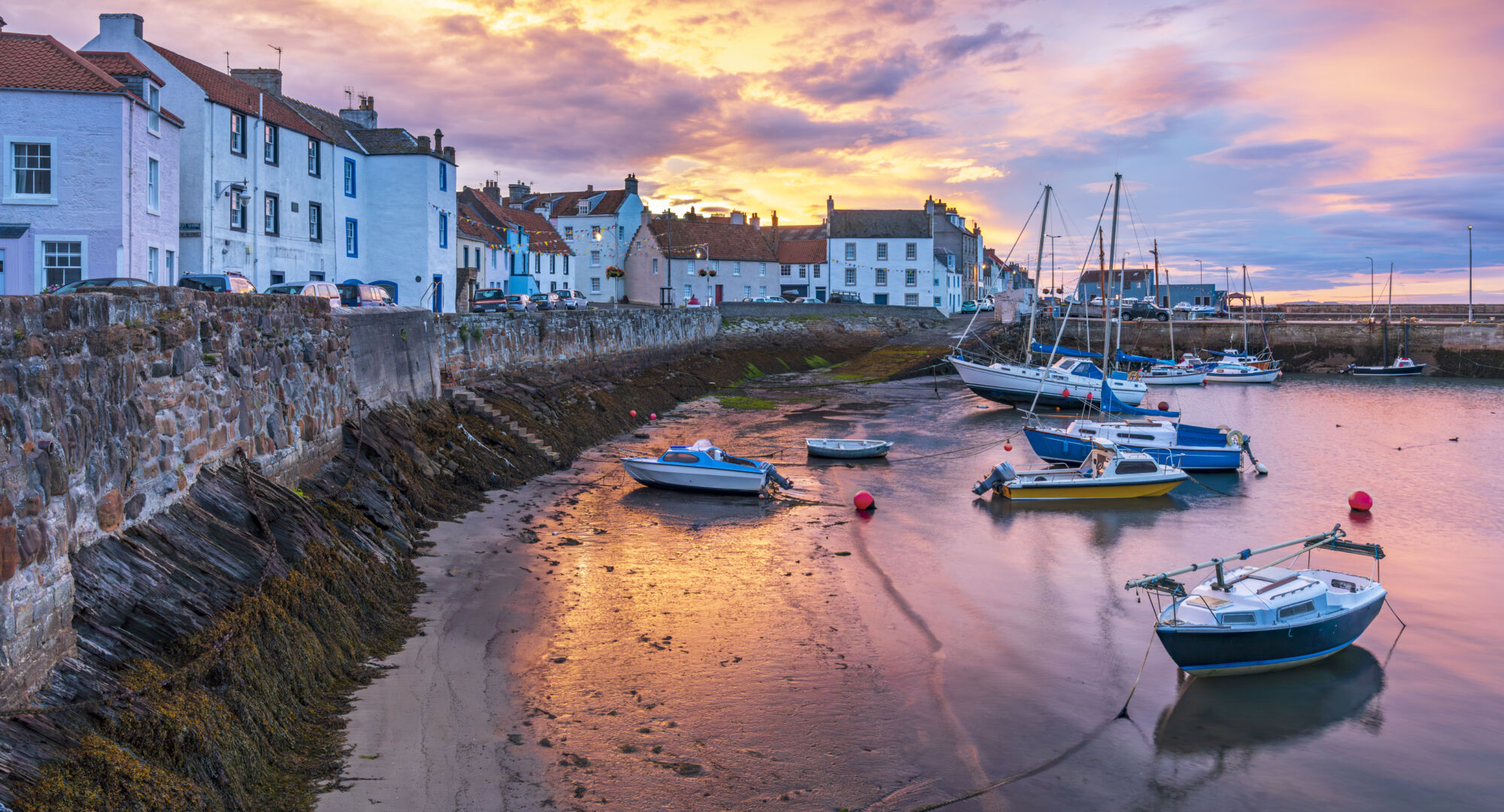 A stunning sunrise over St Monans village harbour in Fife, Scotland