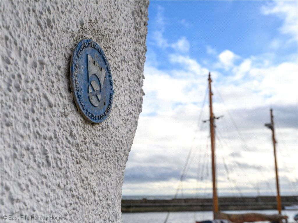 A blue plaque on a white pebble dashed wall