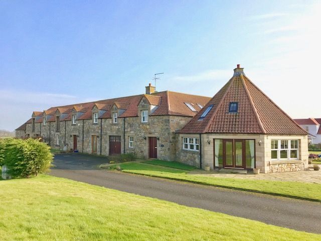 A large stone house with a pointed red roof