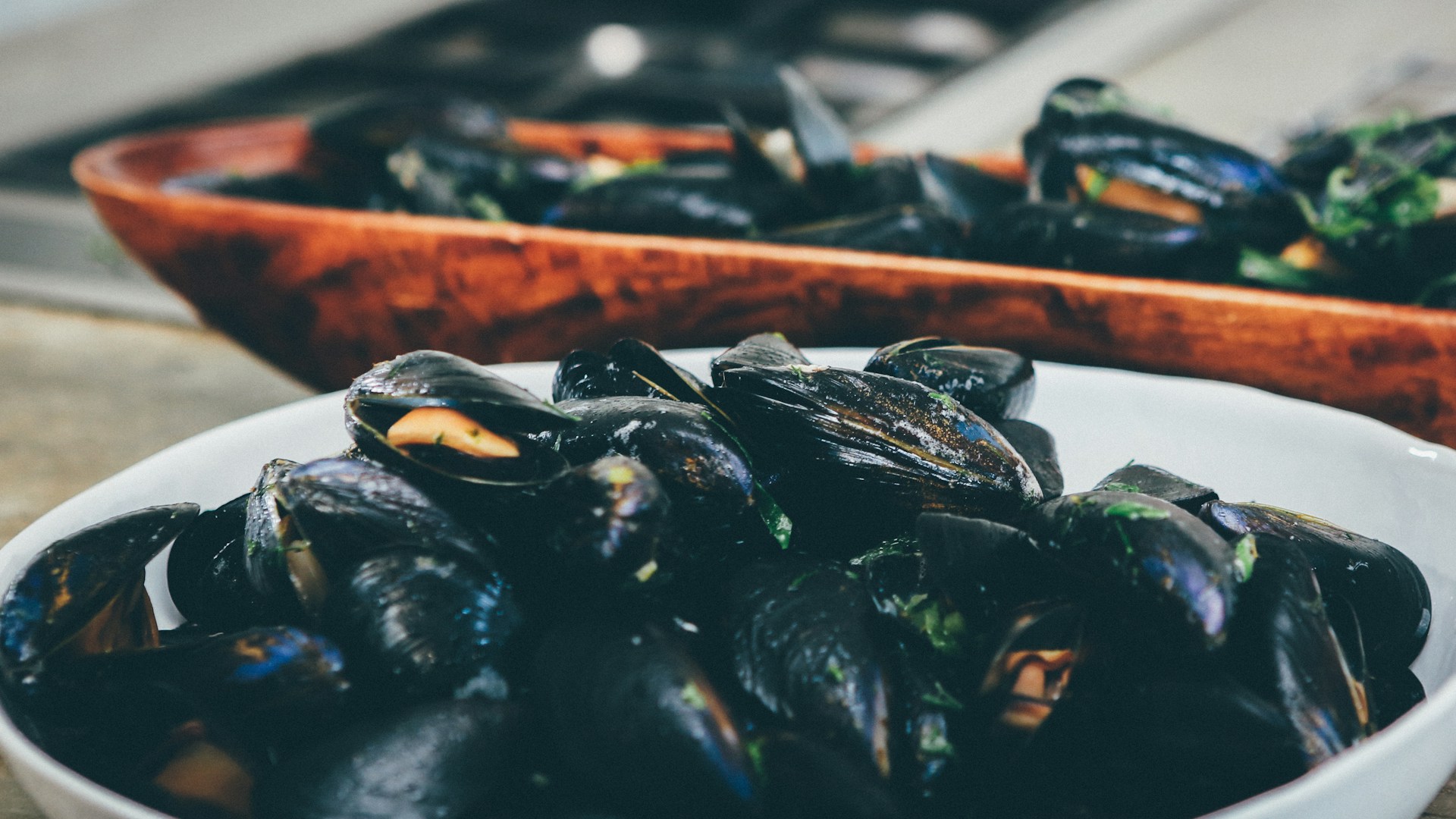 Cooked mussels in a white bowl