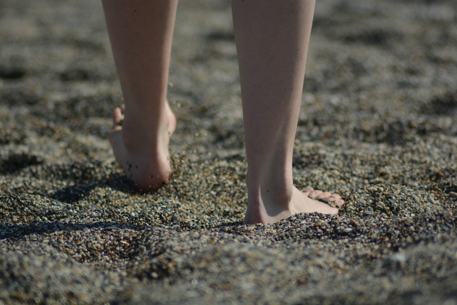 A person standing on brown sand