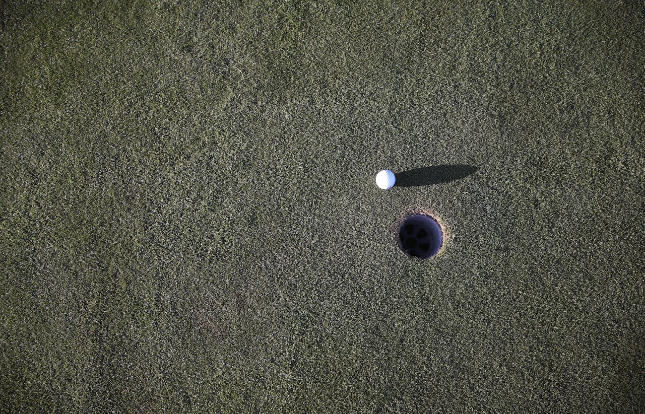 White Golf Ball on Green Grass Field