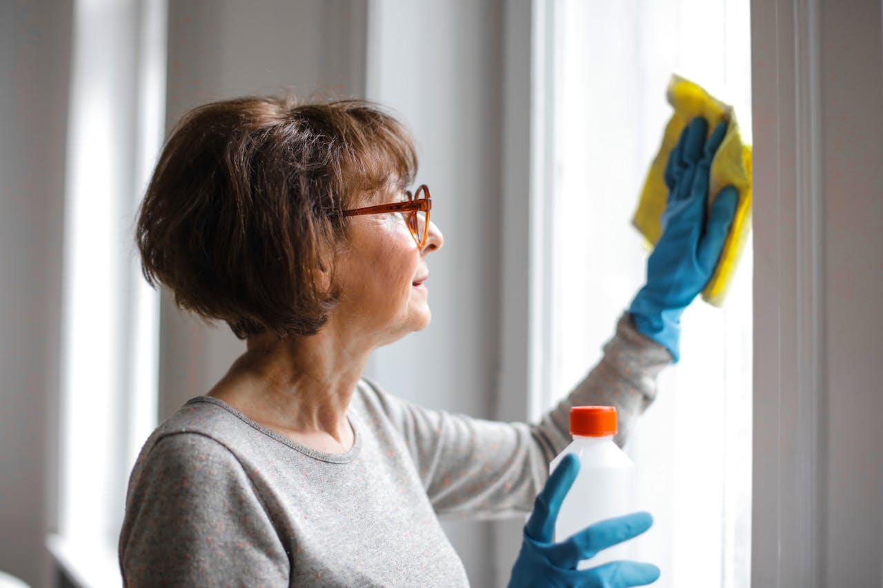 A woman cleaning a window inside