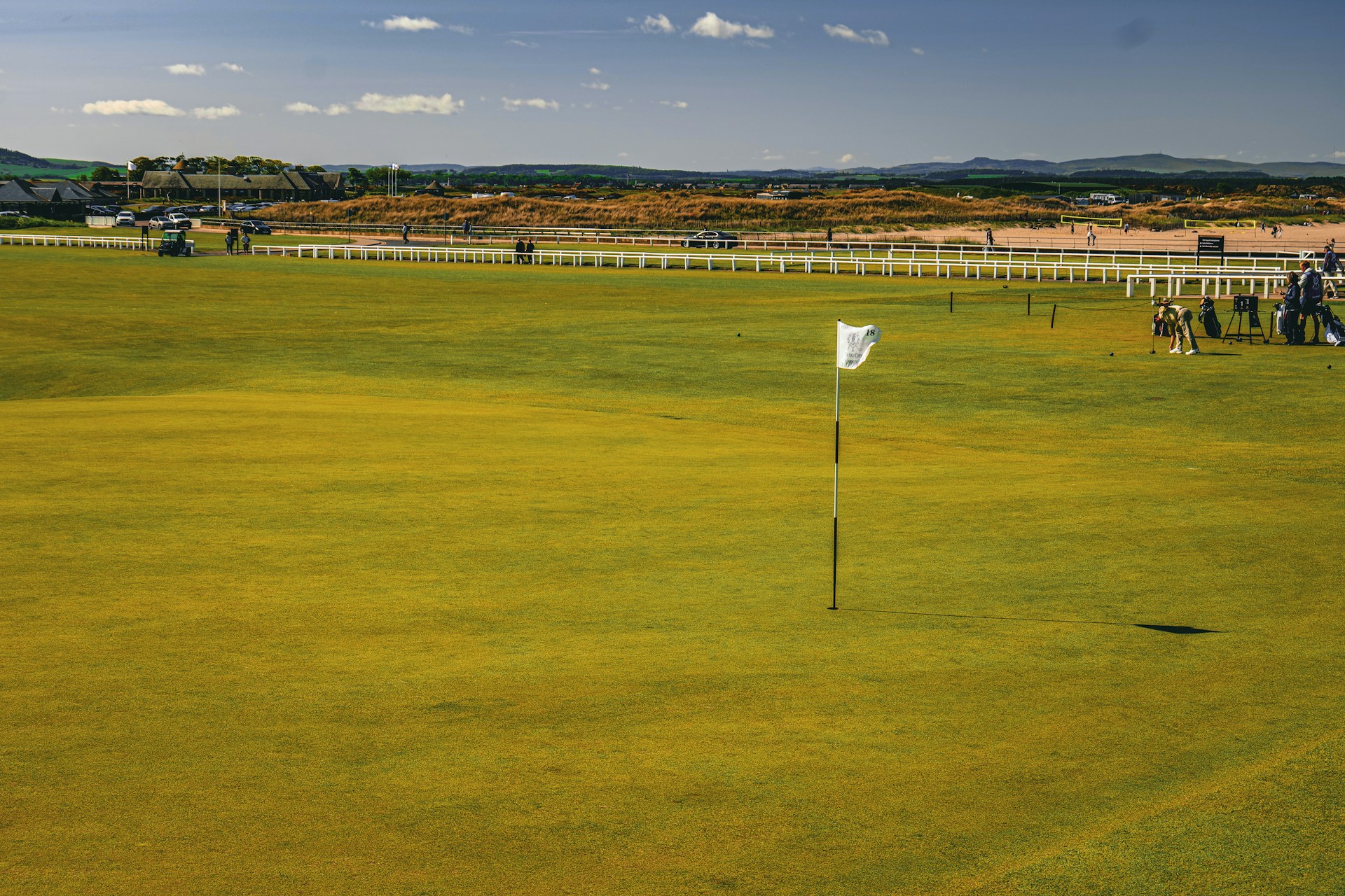 A green field with a white flag in the middle of it