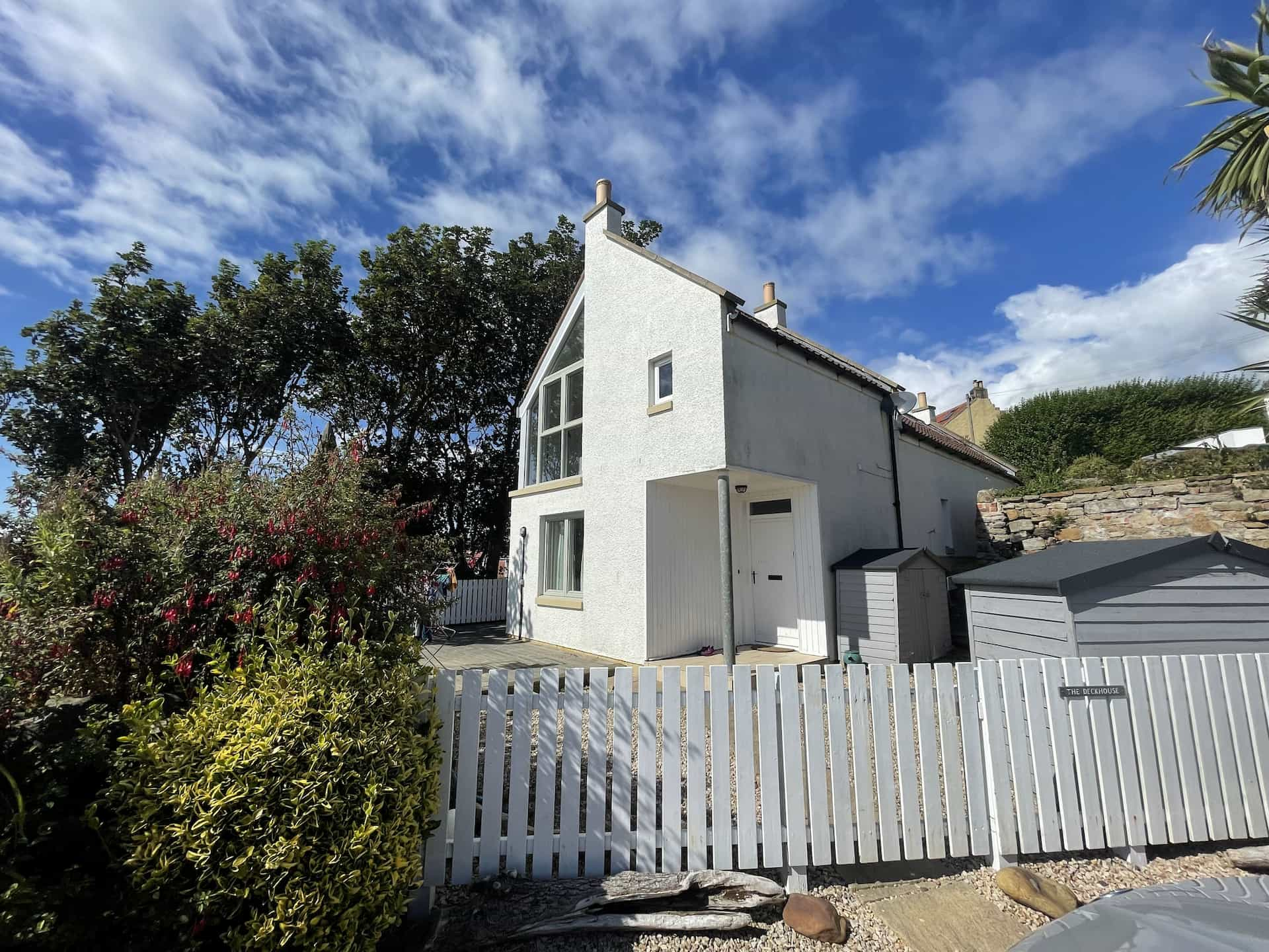 A white house on a hill with a white fence