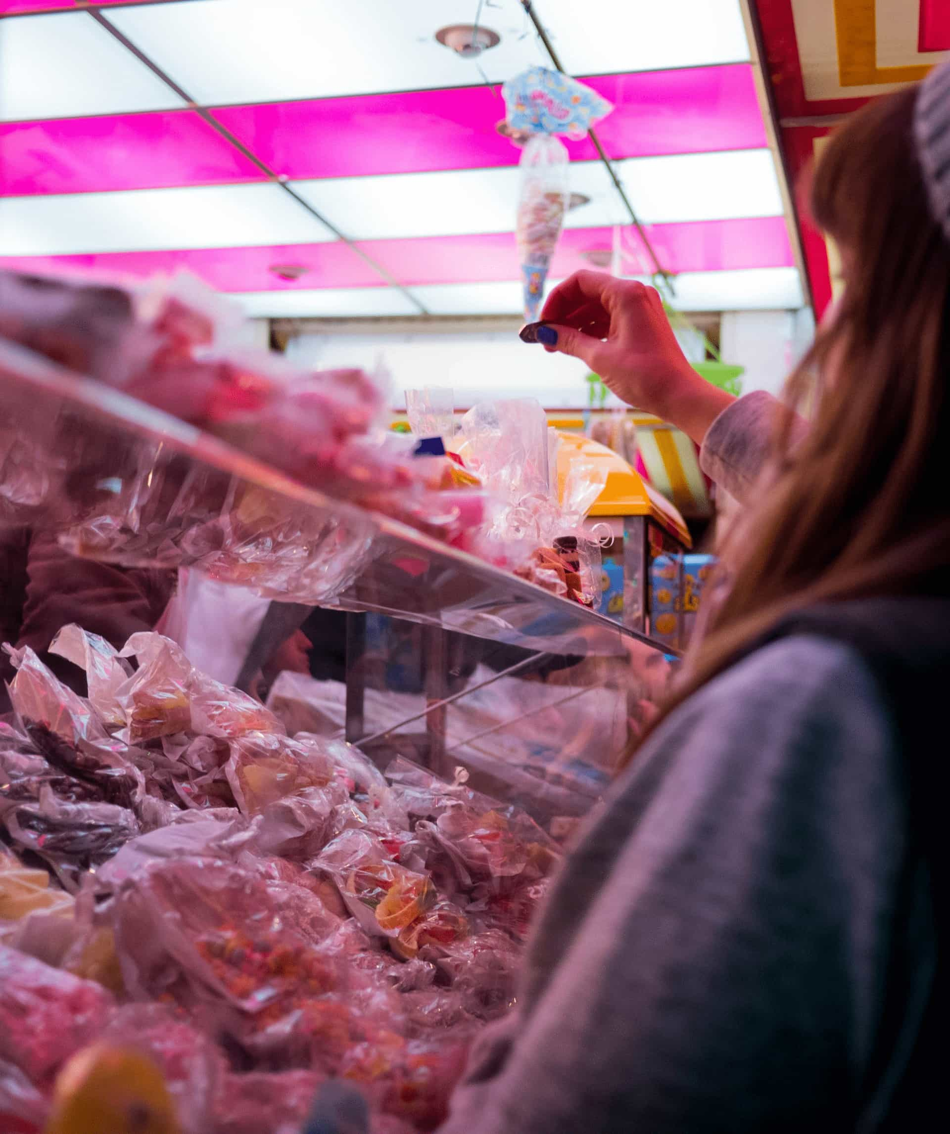 A woman standing in front of a sweet stall