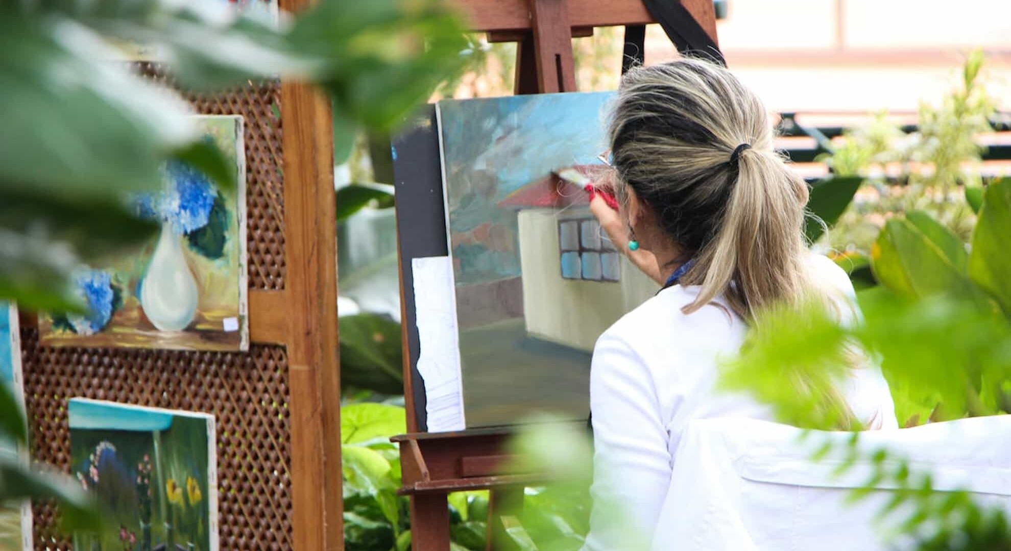 A woman painting outside in a garden