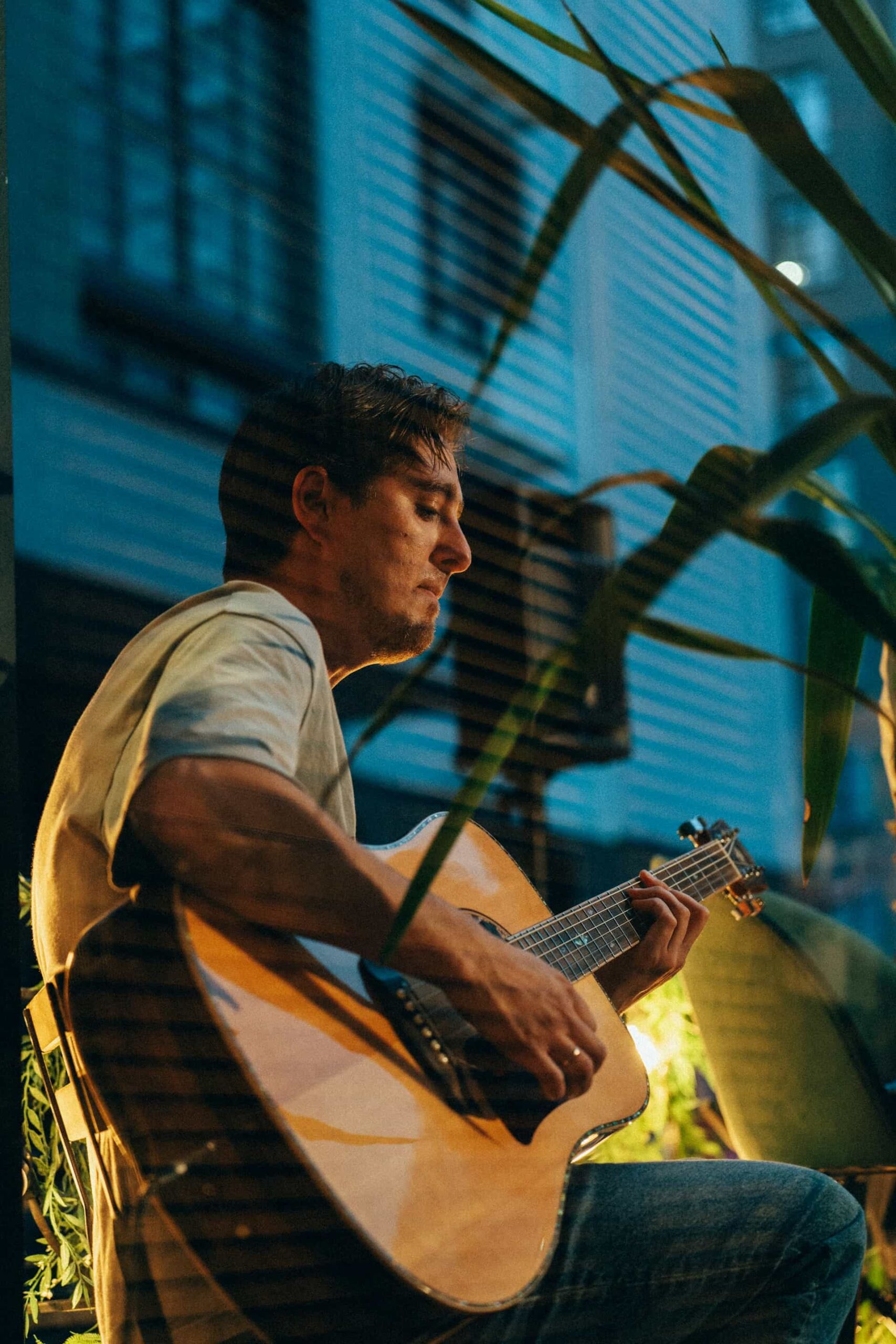 A man sitting in a chair playing guitar